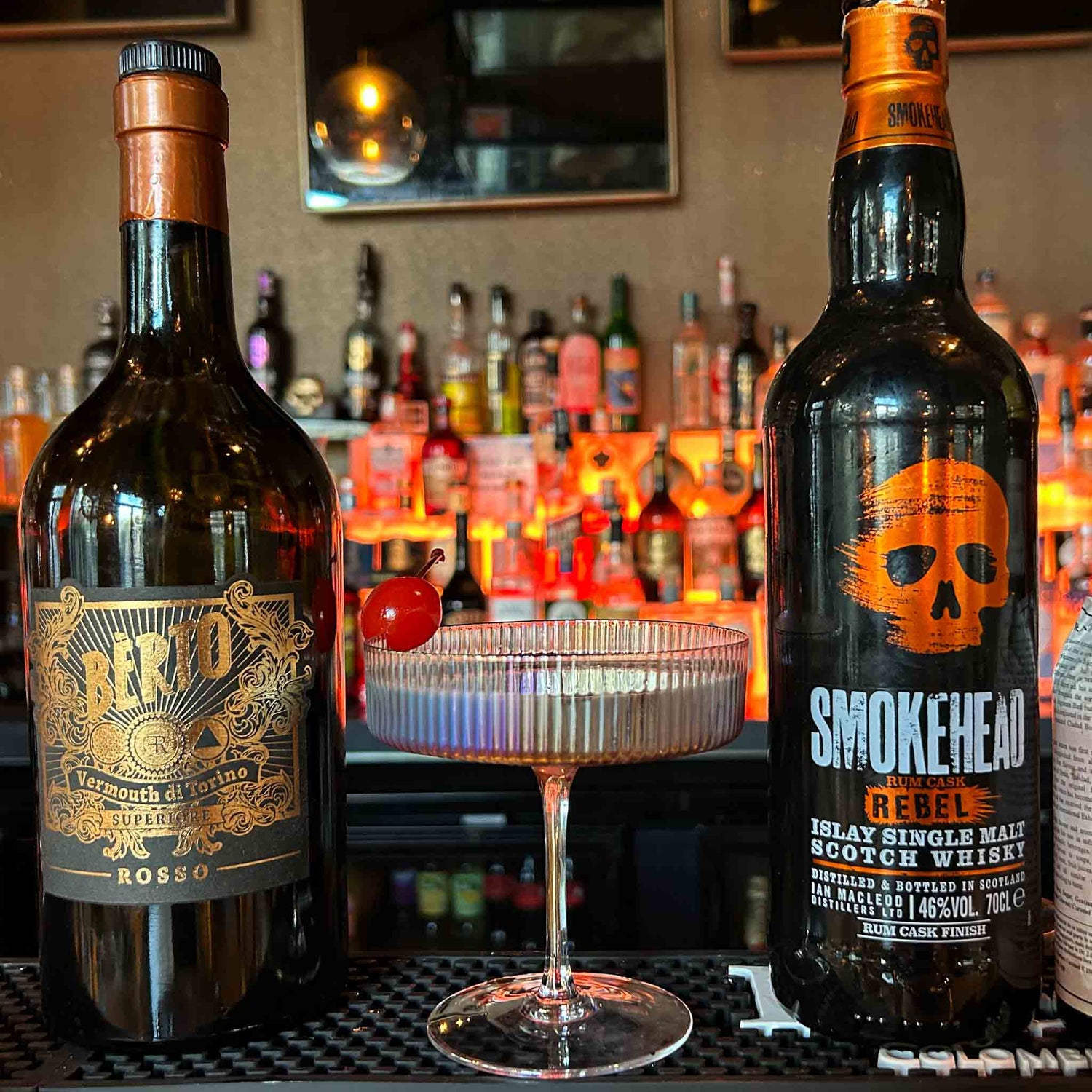 Manhattan cocktail recept met Rye Whiskey, zoete vermout en Angostura bitters, geserveerd in een vintage coupeglas met maraschino kers.