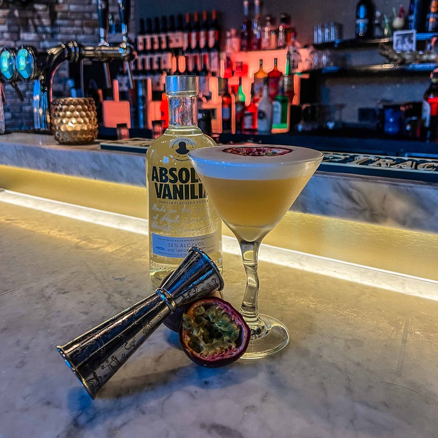 Pornstar Martini cocktail met vanille vodka, passievrucht en schuimlaag, geserveerd in een martiniglas met halve passievrucht als garnering. Cocktail Hotspots Recept