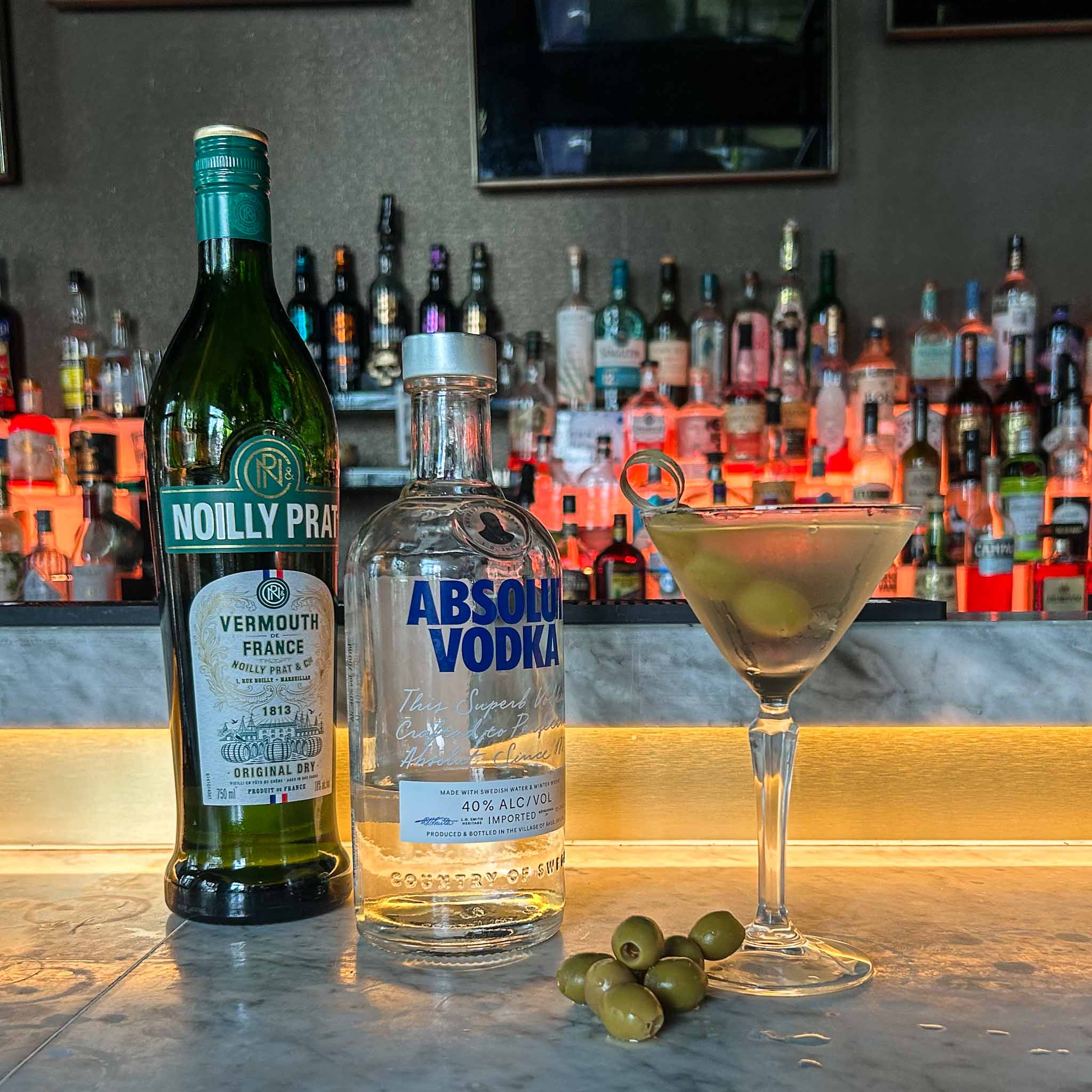 Recept Dirty Martini cocktail met vodka, droge vermouth en groene olijven, geserveerd in een gekoeld martiniglas.