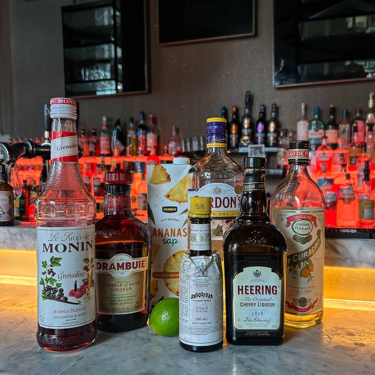 Singapore Sling cocktail met gin, kersenlikeur en ananas, geserveerd met ijs en garnering van ananas en kers.