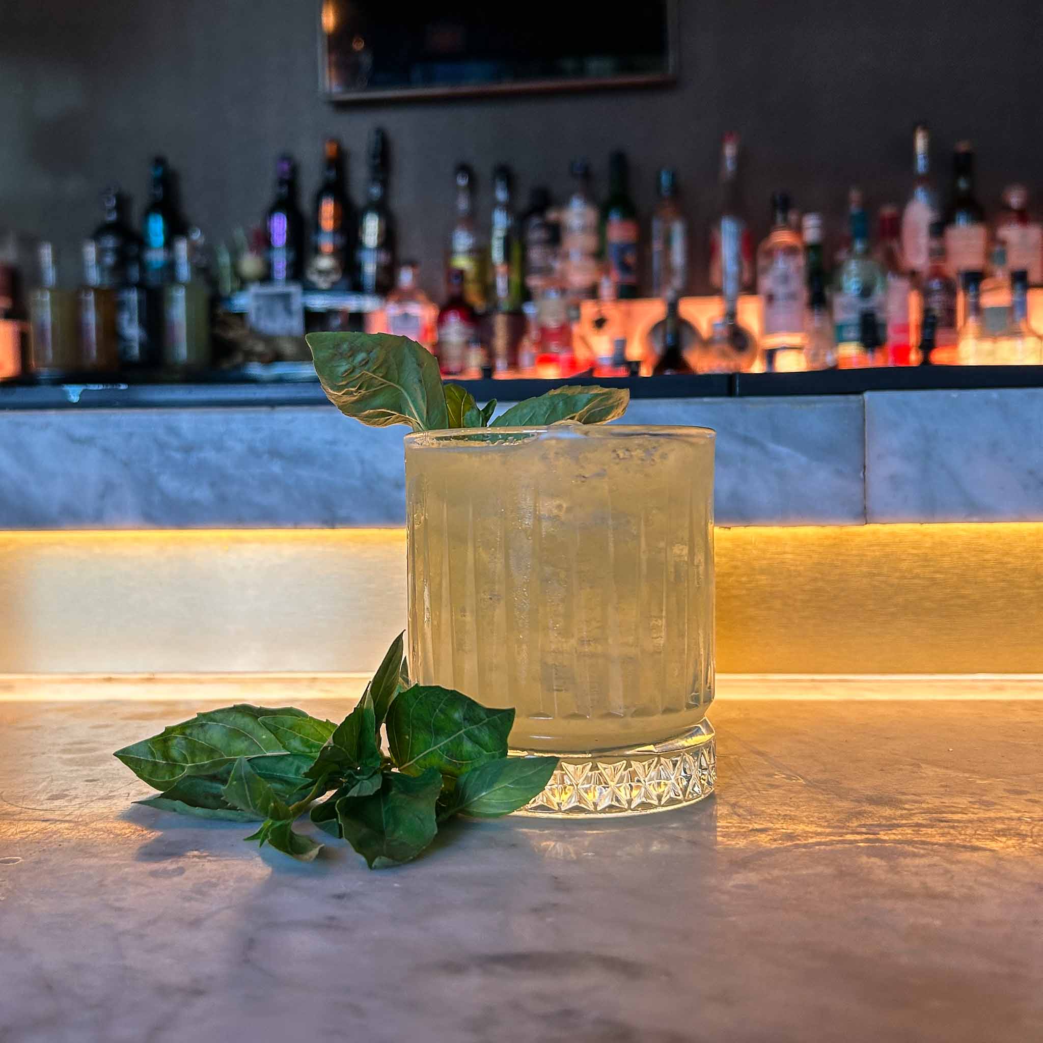 Gin Basil Smash recept met verse basilicum, gin en limoensap. Een verfrissende en kruidige cocktail, perfect voor zomerse dagen. Cocktail Hotspots