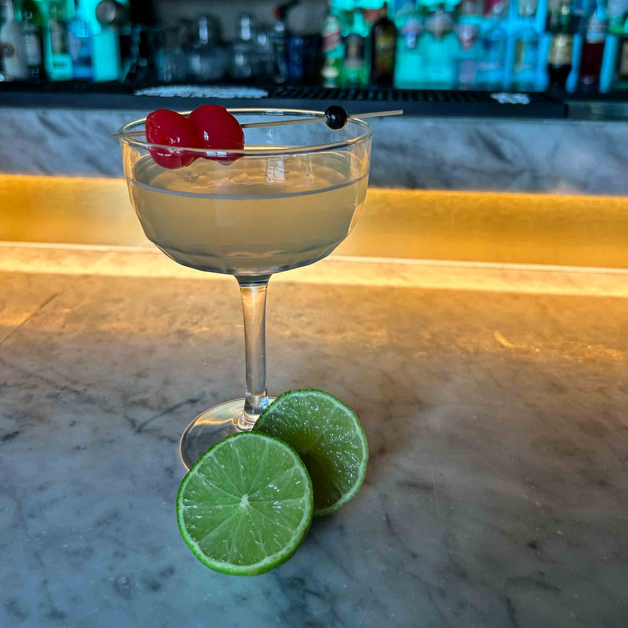 Last Word cocktail recept met gin, Chartreuse, maraschino likeur en limoensap geserveerd in een gekoeld coupeglas met cocktailkers.