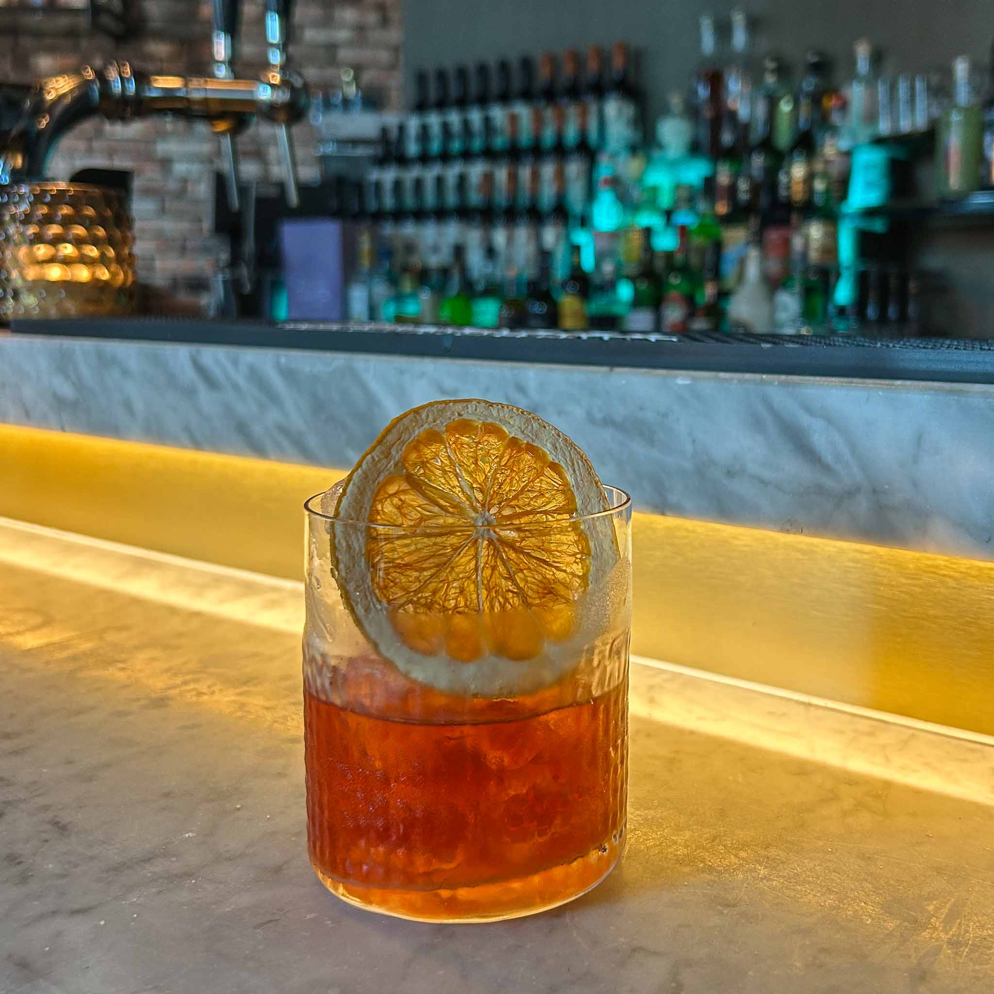 Rum Fashioned cocktail recept met gerijpte rum, rietsuiker en bitters in tumblerglas met sinaasappel. cocktail hotspots recept old fashioned.