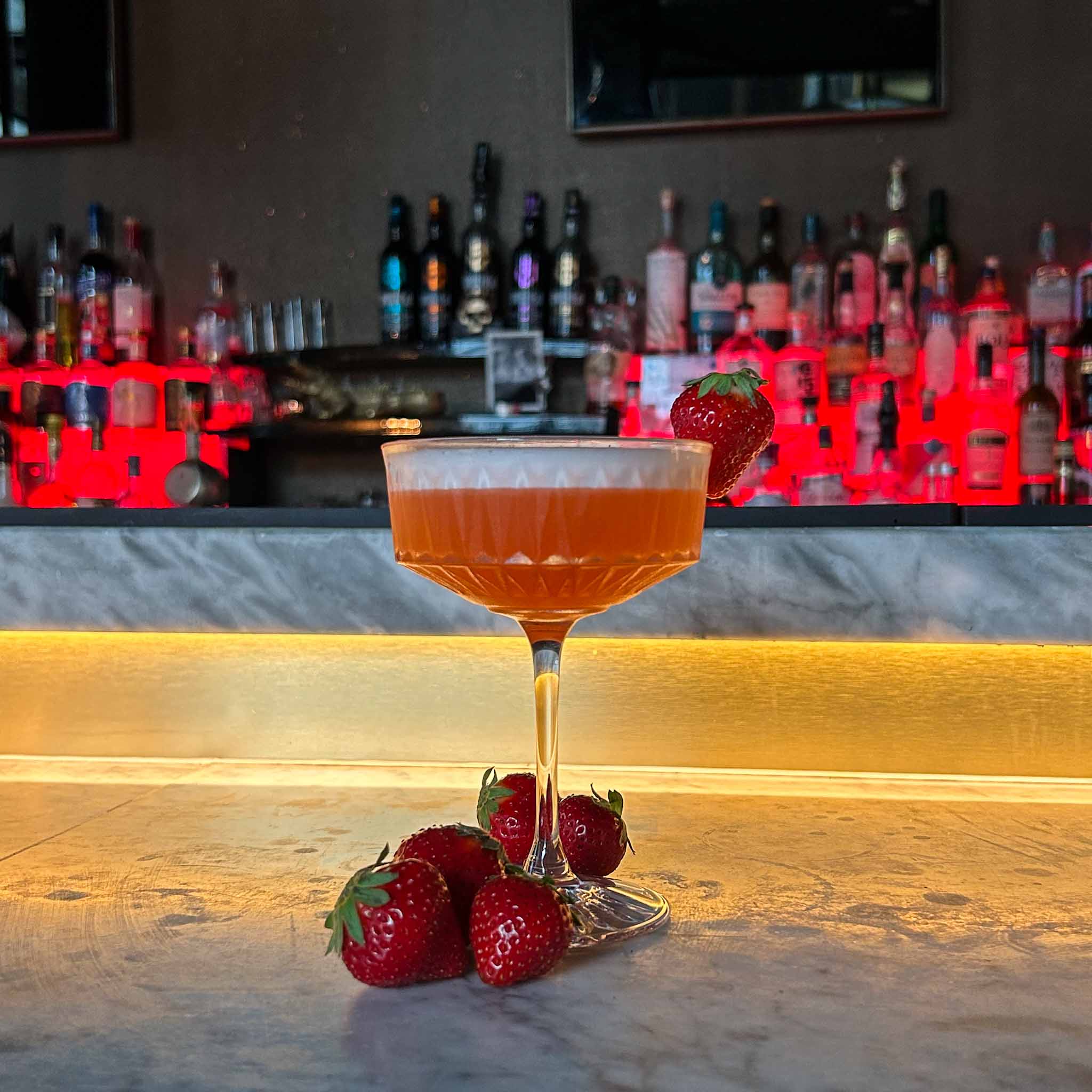 Cocktail recept: Strawberry Fields. Een frisse, zomerse mix van vodka, aardbei en honing, afgewerkt met een romige schuimkraag en een aardbeitje.